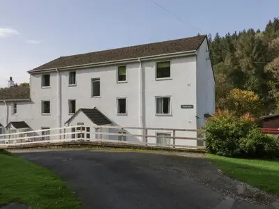 a large white building with a fence around it at Apartment 6 in Keswick