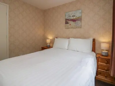 a bedroom with a large white bed with two night stands at Apartment 1 in Keswick