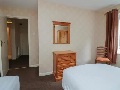 a bedroom with a bed and a dresser and a mirror at Apartment 1 in Keswick
