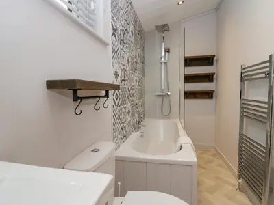 a white bathroom with a toilet and a sink at The Bothy in Keswick