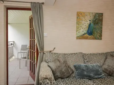 a living room with a couch and a picture of a peacock at Apartment 3 in Keswick