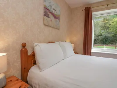 a bedroom with a white bed and a window at Apartment 3 in Keswick