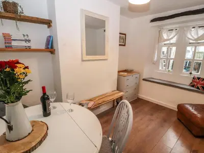 a dining room with a table with a vase of flowers at Kestrel Cottage in Keswick