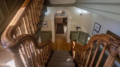 a stairway with wooden railings and a stair case at CastlegateTownhouse in Cockermouth