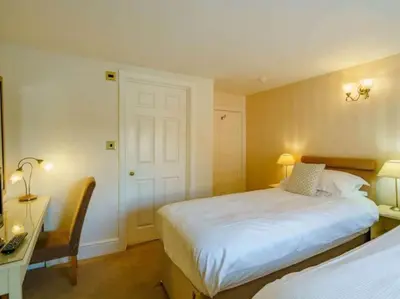 a bedroom with a bed and a desk with a computer at CastlegateTownhouse in Cockermouth