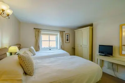 a hotel room with two beds and a television at CastlegateTownhouse in Cockermouth