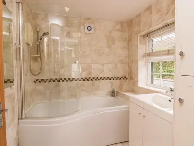 a bathroom with a tub and a sink at Thwaite How in Keswick