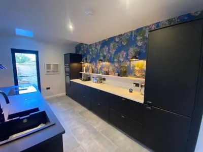 a kitchen with black cabinets and floral wallpaper at Kirkcudbright 3 bed ultra modern brand new in Kirkcudbright
