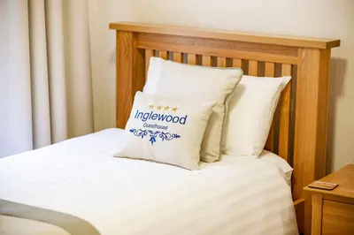 a bed with a wooden headboard with a pillow on it at OPUL EXPRESS - Inglewood in Douglas