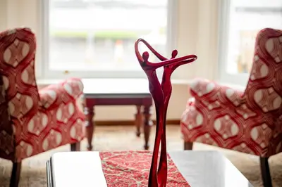 a red vase sitting on a table with two chairs at OPUL EXPRESS - Inglewood in Douglas
