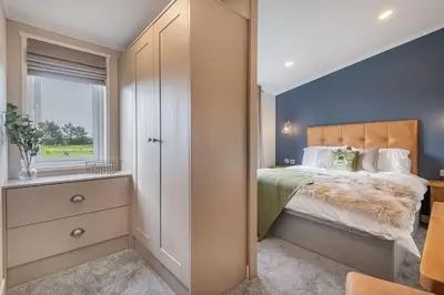a bedroom with a large bed and a window at Oak Tree Timber Holiday Lodge in Bassenthwaite