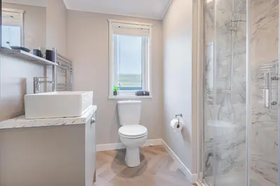 a bathroom with a toilet and a sink and a shower at Oak Tree Timber Holiday Lodge in Bassenthwaite
