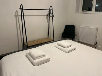 a bedroom with a bed with three towels on it at The Boyd - Coorie Doon in Prestwick