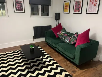a living room with a green couch and a table at The Boyd - Coorie Doon in Prestwick