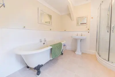 a white bathroom with a tub and a sink at Historic St Bees Farmhouse Hot Tub Games Summer Gatherings in St Bees