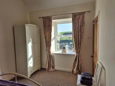 a bedroom with a window and a dresser at RAWSON COTTAGE LOVELY 2 BEDROOM SEMI RURAL in Stranraer