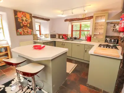 a kitchen with a counter and a island with stools at Beck Edge in Keswick