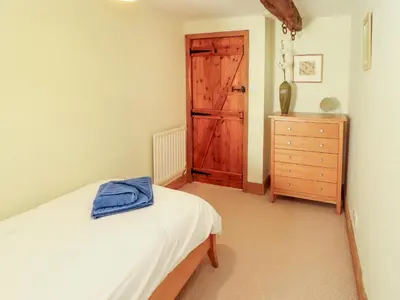 a bedroom with a bed and a wooden door at Beck Edge in Keswick