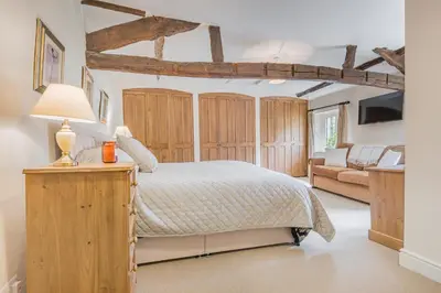 a bedroom with a bed with wooden cabinets and a couch at farmhouse braithwaite mews in Keswick