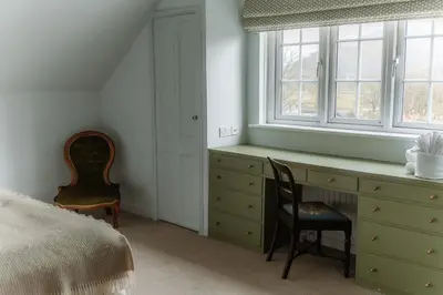 a bedroom with a desk and two chairs and a window at Grey Walls in Penrith