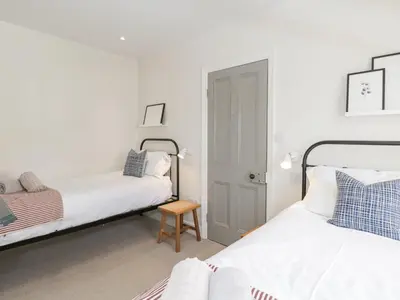 a bedroom with two beds and a stool in it at Forty Five in Keswick