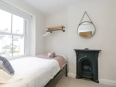 a bedroom with a fireplace and a mirror on the wall at Forty Five in Keswick