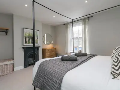 a bedroom with a large bed and a fireplace at Forty Five in Keswick