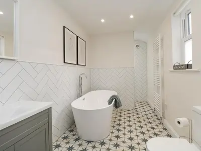 a white bathroom with a tub and a sink at Forty Five in Keswick