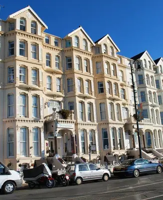 a large building with cars parked in front of it at Trevelyan Hotel in Douglas