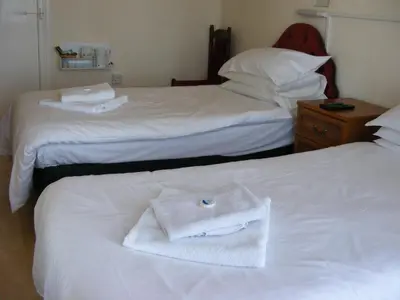 a hotel room with two beds with a towel on the bed at Trevelyan Hotel in Douglas