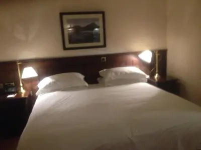 a bedroom with a large white bed with two lamps at Trevelyan Hotel in Douglas