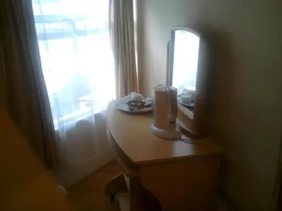 a room with a desk with a mirror and a computer monitor at Trevelyan Hotel in Douglas