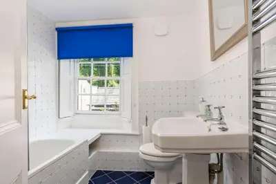 a bathroom with a sink and a tub and a toilet at Bridge Cottage Keswick in Keswick
