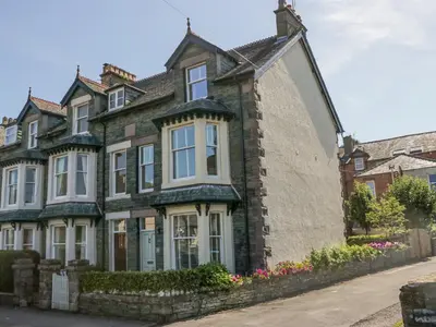 a large brick house with white windows on a street at Heatherlea in Keswick