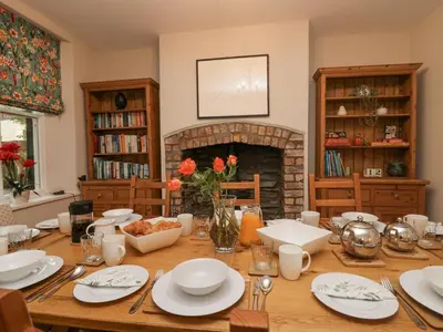 a dining room with a table and a fireplace at Heatherlea in Keswick