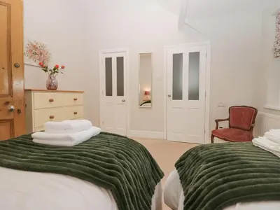 a bedroom with two beds with green and white blankets at Heatherlea in Keswick