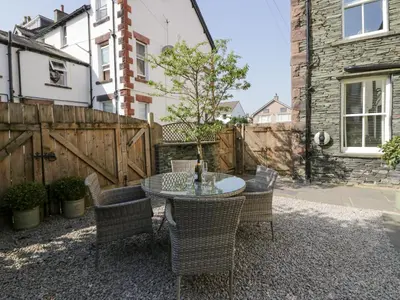 a patio with a table and chairs and a fence at Heatherlea in Keswick