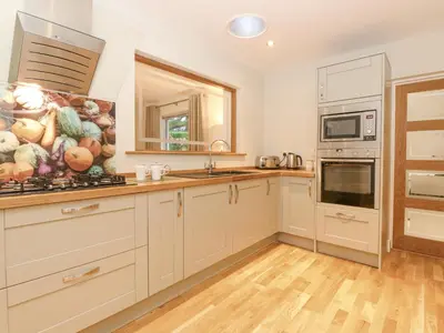a kitchen with white cabinets and a sink at Tandarra in Keswick