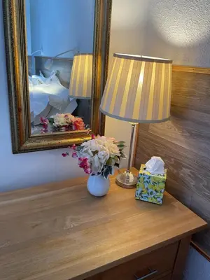 a lamp and a vase with flowers on a table at The Hutchinson Apartments in Douglas