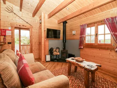 a living room with a couch and a fire place at Ballinorig Lodge in Cleator Moor