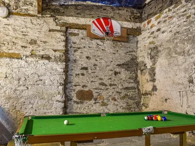 a pool table in a room with a ball on it at Church House Cottage in Ulpha