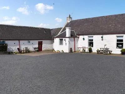 a couple of white buildings with a parking lot at Muirston Farmhouse - Uk44977 in Ayr