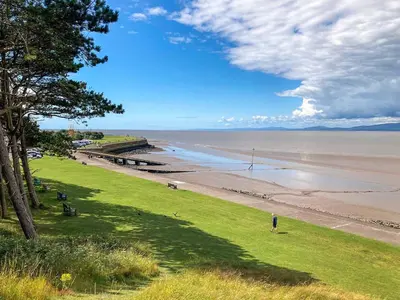 a person standing on the grass near a beach at The Police Station - Uk45642 in Silloth