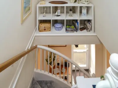 a stairway with a white book shelf at Clachries Cottage in Boreland of Colvend