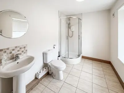 a bathroom with a shower and a toilet and a sink at The Old Cheese Loft in Colfin