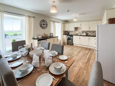 a kitchen and dining room with a table and chairs at The Old Cheese Loft in Colfin
