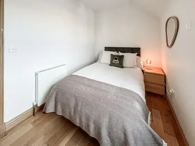 a small bedroom with a bed and a mirror at The Old Cheese Loft in Colfin