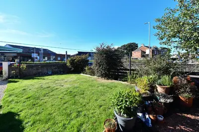 a garden with potted plants on the grass at The Lemon Tree in Prestwick