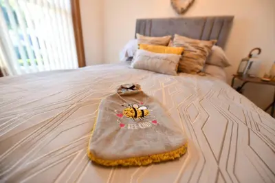 a bed with a blanket with a honey bee on it at The Lemon Tree in Prestwick