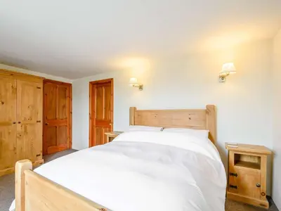 a bedroom with a large white bed and wooden cabinets at 1 Bed in Eskdale SZ503 in Beckfoot
